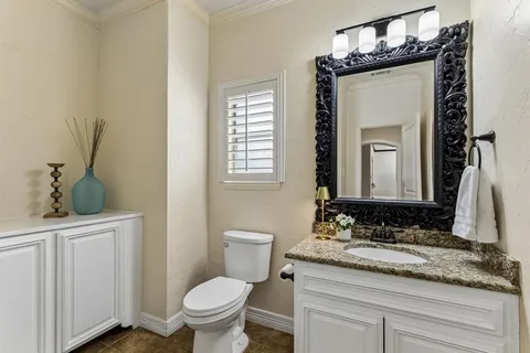 a bathroom with a granite countertop sink toilet and mirror