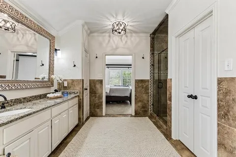 a spacious bathroom with a granite countertop sink a mirror and shower