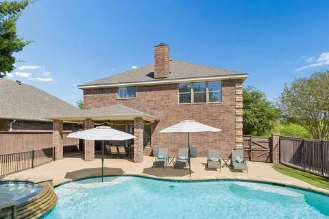 a patio with a table and chairs under an umbrella