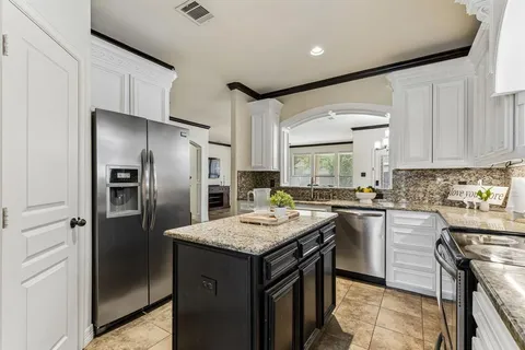 a kitchen with stainless steel appliances granite countertop a refrigerator a stove a sink and a refrigerator