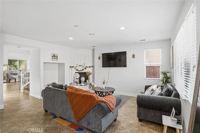 a room with stainless steel appliances kitchen island granite countertop a table chairs in it and a window