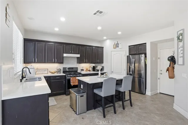 a kitchen with a sink a refrigerator and wooden cabinets