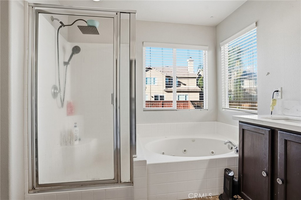 3902 Bluff Street Perris, CA 92571 - Photo 29 of 44 a bathroom with a bathtub a shower a sink and a window