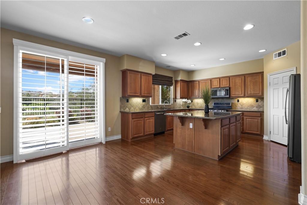 35107 Hogan Drive Beaumont, CA 92223 - Photo 13 of 47 a kitchen with refrigerator cabinets and wooden floor