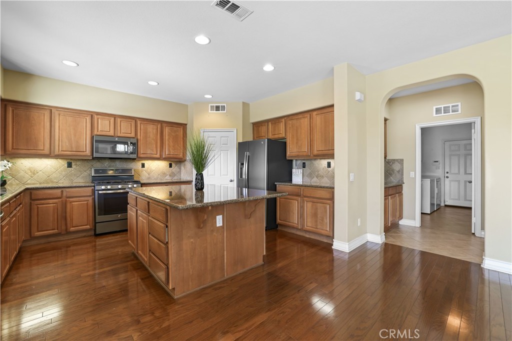 35107 Hogan Drive Beaumont, CA 92223 - Photo 15 of 47 a kitchen with stainless steel appliances granite countertop a stove top oven a refrigerator a sink and a oven