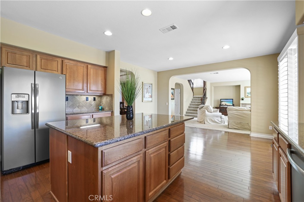 35107 Hogan Drive Beaumont, CA 92223 - Photo 16 of 47 a kitchen with stainless steel appliances granite countertop a refrigerator a sink dishwasher a stove and a refrigerator with wooden floor