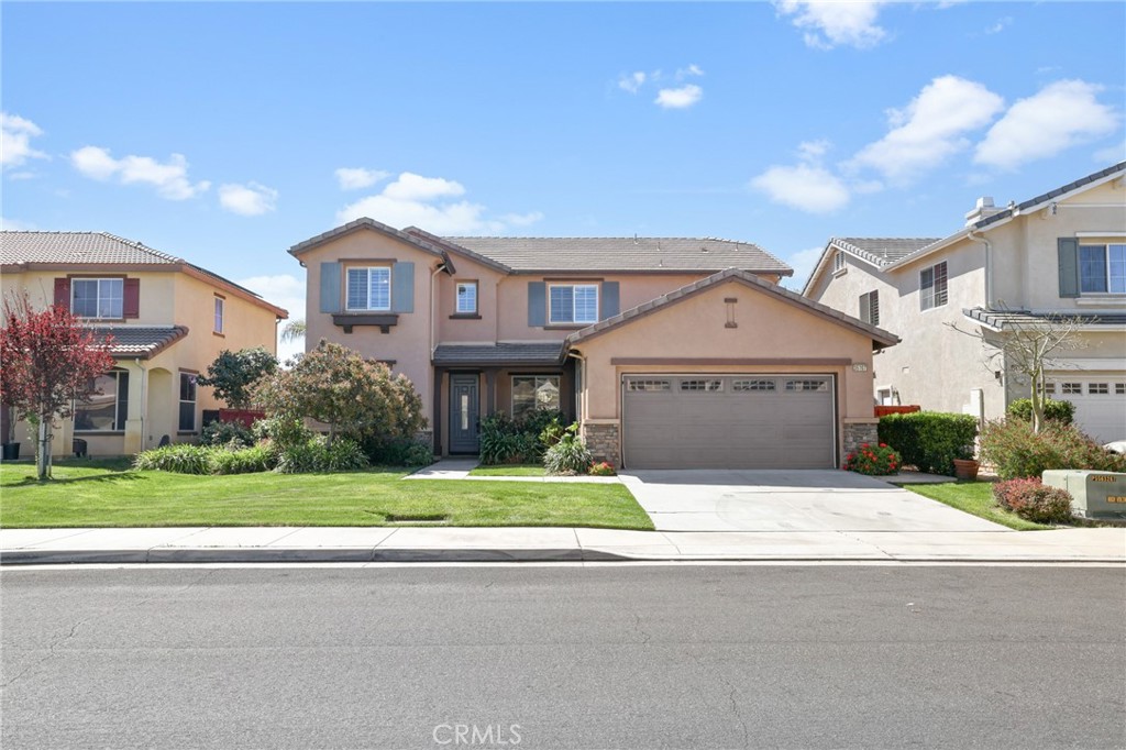 35107 Hogan Drive Beaumont, CA 92223 - Photo 2 of 47 a front view of a house with a yard and a garage