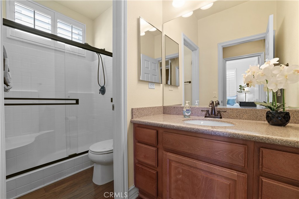 35107 Hogan Drive Beaumont, CA 92223 - Photo 22 of 47 a bathroom with a granite countertop sink a toilet and a mirror