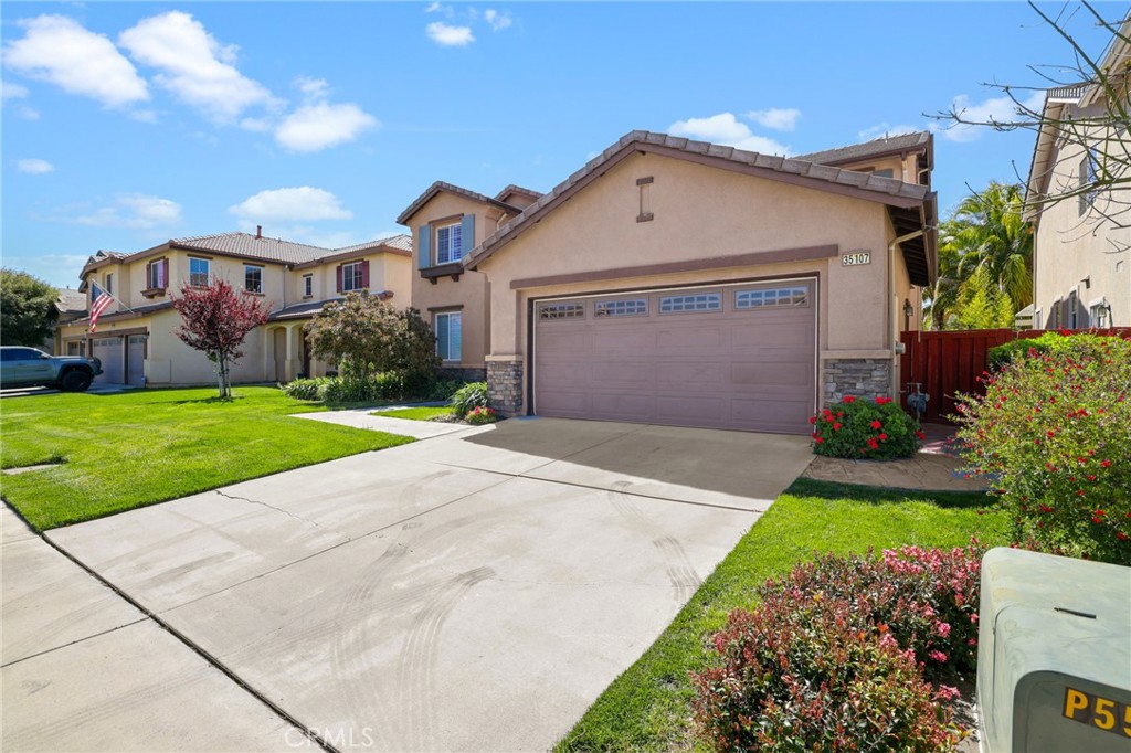 35107 Hogan Drive Beaumont, CA 92223 - Photo 3 of 47 a front view of a house with a yard and garage
