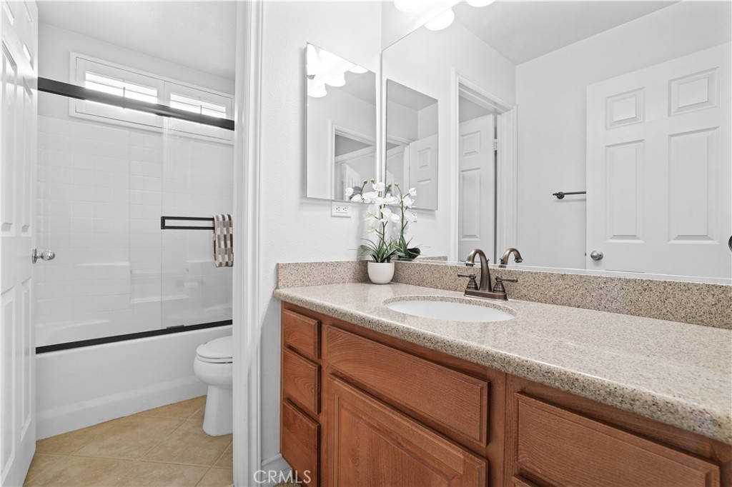 35107 Hogan Drive Beaumont, CA 92223 - Photo 39 of 47 a bathroom with a granite countertop sink mirror vanity and toilet