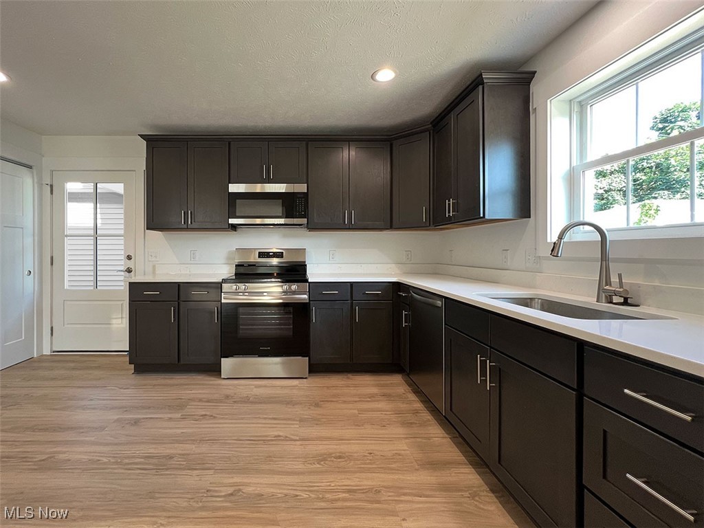 3630 Menlo Road Shaker Heights, OH 44120 - Photo 6 of 26 Kitchen with stainless steel appliances, light wood-type flooring, kitchen window, recessed lighting, and quartz counters