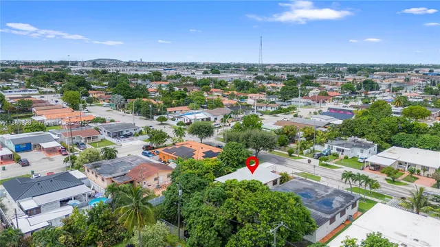 an aerial view of a house with a garden and large trees