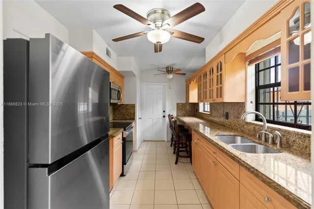a kitchen with stainless steel appliances granite countertop a sink refrigerator and cabinets