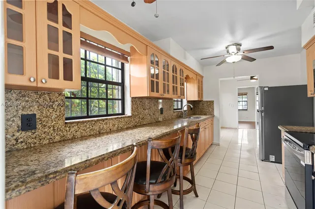 a kitchen with stainless steel appliances granite countertop a stove a sink and a refrigerator