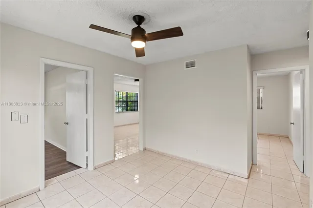 an empty room and chandelier fan