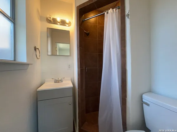 a bathroom with a sink and mirror with toilet