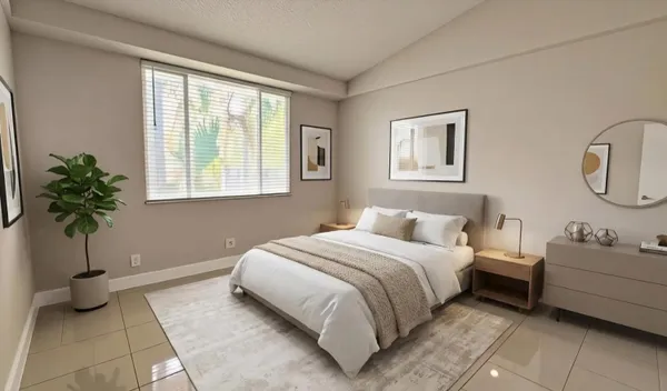 a bedroom with a bed a couch and potted plant