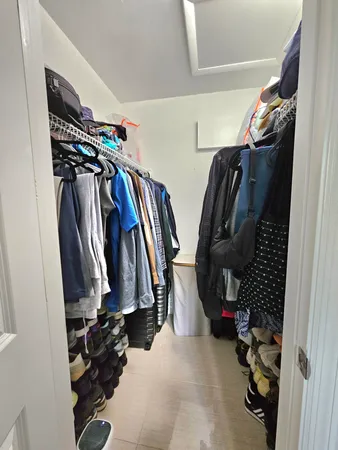 a view of walk in closet with clothes