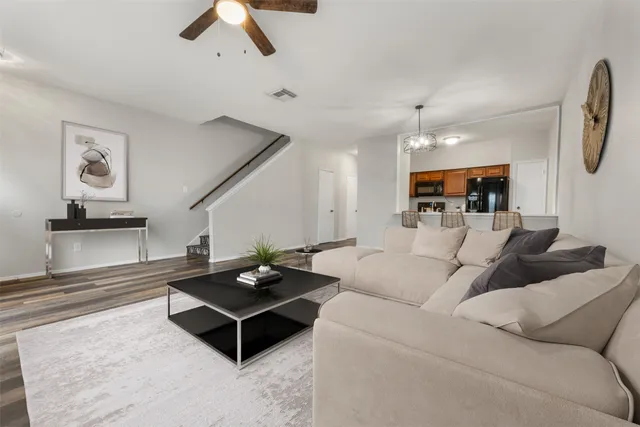 a living room with furniture and a ceiling fan
