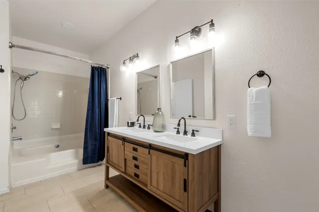 a bathroom with a double vanity sink mirror double and shower