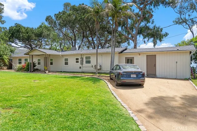 a view of backyard with a table and chairs under an umbrella