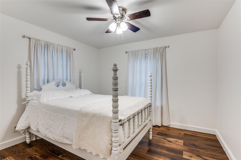 606 Quiram Lane Kemp, TX 75143 - Photo 16 of 23 a bedroom with a bed and a chandelier