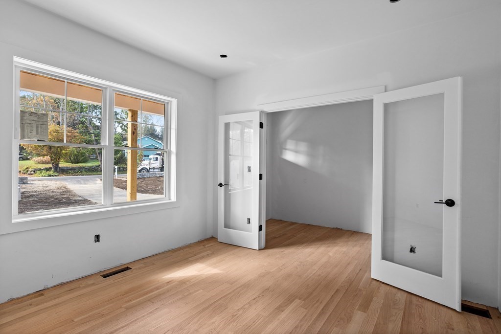 6 Nashoba Road Acton, MA 01720 - Photo 5 of 42 an empty room with wooden floor and windows