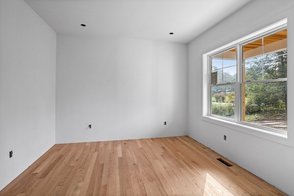 6 Nashoba Road Acton, MA 01720 - Photo 6 of 42 a view of an empty room with wooden floor and a window