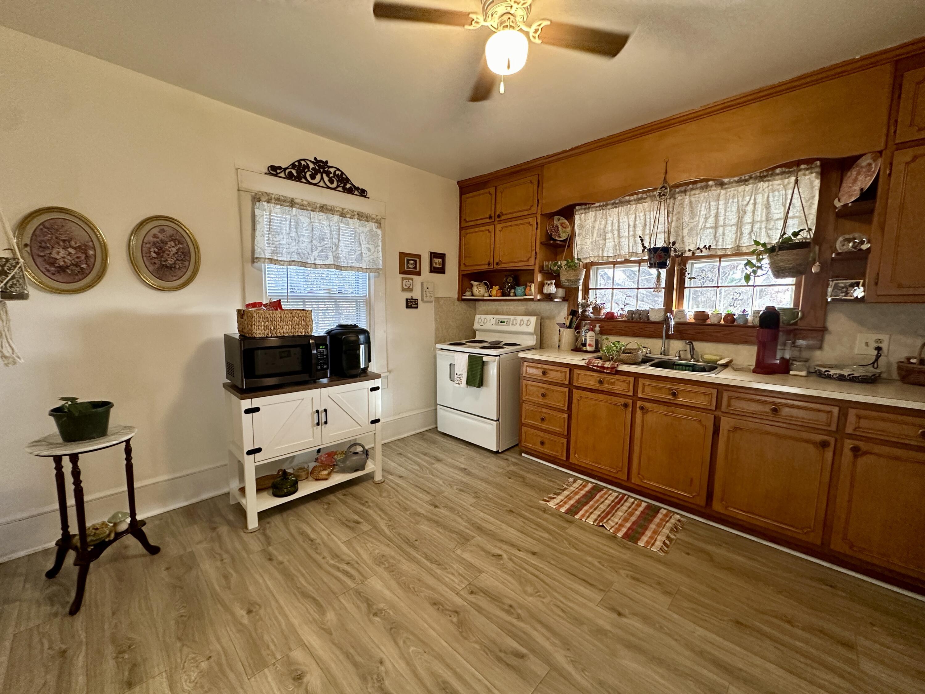 60 Soapstone Road Ridgeway, VA 24148 - Photo 8 of 26 a kitchen with a stove a refrigerator and a sink with wooden floor