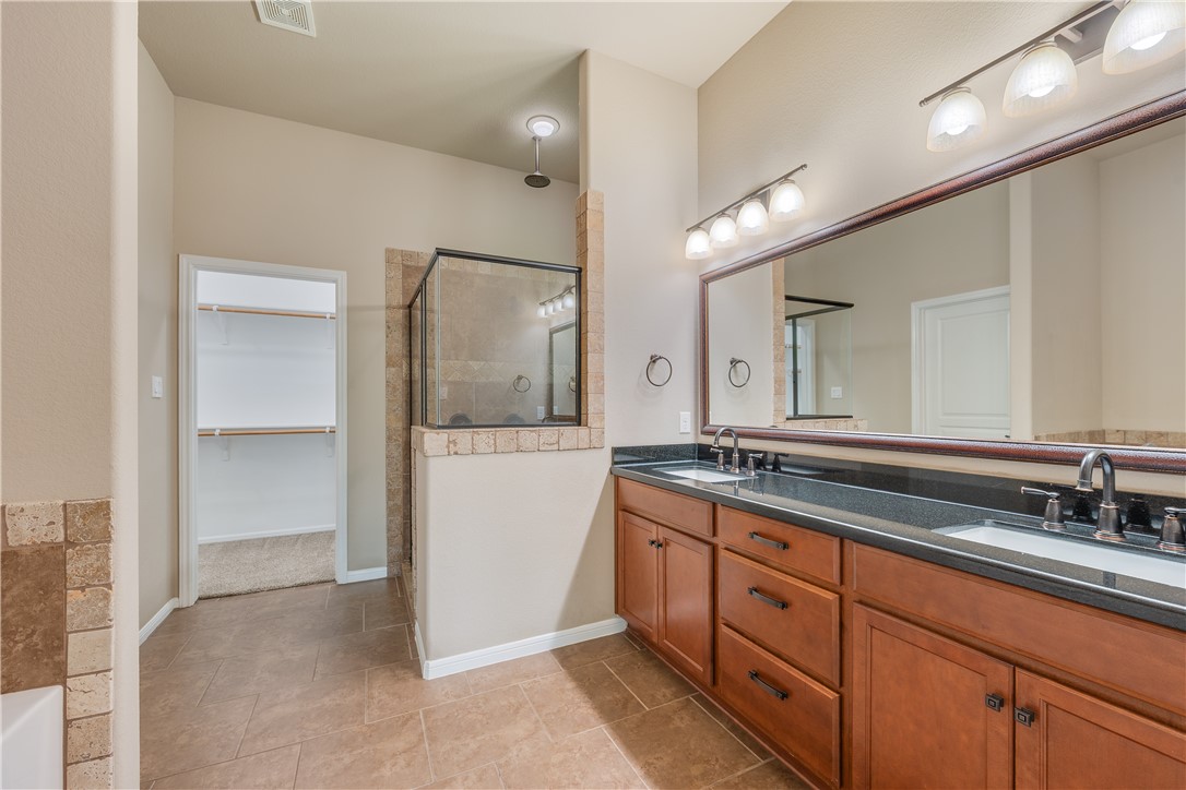 3085 Archer Circle Bryan, TX 77808 - Photo 11 of 31 a spacious bathroom with a granite countertop sink and a mirror