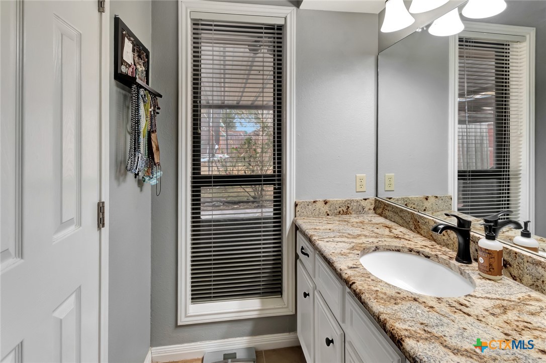 101 Kemble Street Victoria, TX 77904 - Photo 25 of 34 a bathroom with a granite countertop sink and a mirror
