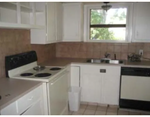 a kitchen with a sink cabinets and a window