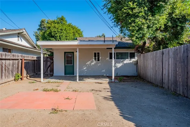 a view of a barn house next to a yard with wooden fence