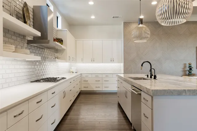 a kitchen with stainless steel appliances granite countertop a sink and a stove