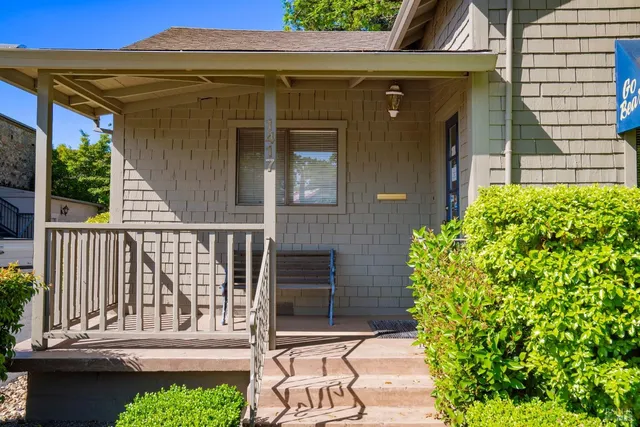 a view of a chair and table in the patio with potted plants