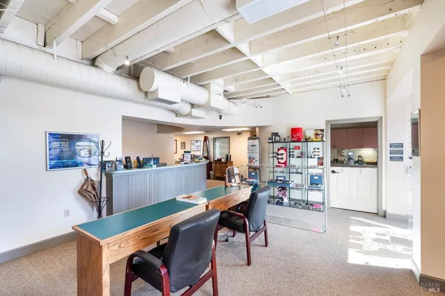 a view of a dining room with furniture and a kitchen