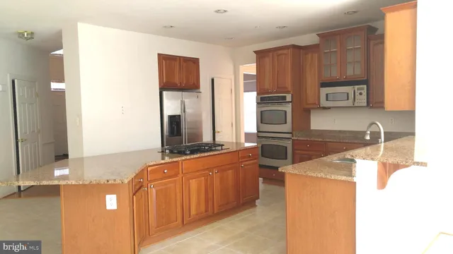 a kitchen with stainless steel appliances granite countertop a sink and a stove