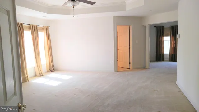 a view of a room with a windows and ceiling fan