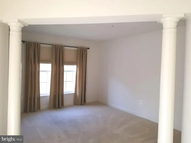 a view of an empty room with large windows