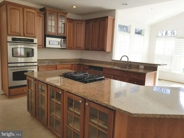 a kitchen with stainless steel appliances granite countertop a sink stove and microwave