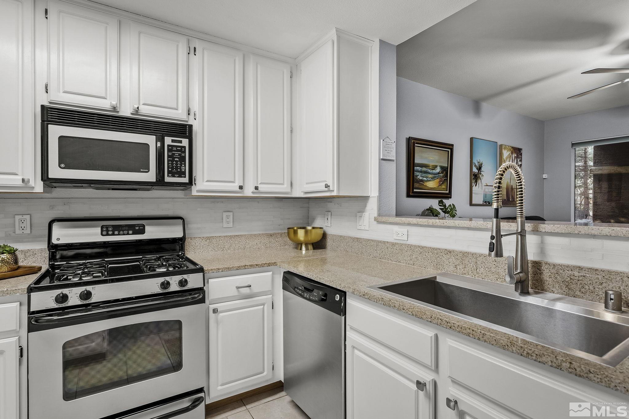 900 South Meadows Parkway, Unit 2012 Reno, NV 89521 - Photo 7 of 17 a kitchen with granite countertop a sink stove and microwave