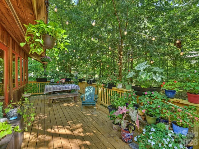 a view of a patio with table and chairs with wooden floor and fence
