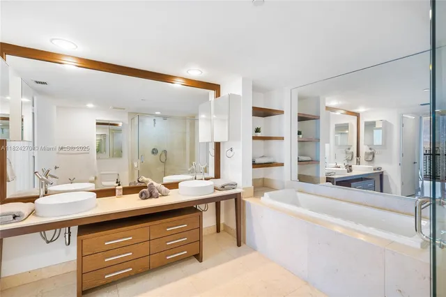 a large bathroom with a double vanity sink a mirror and a bathtub