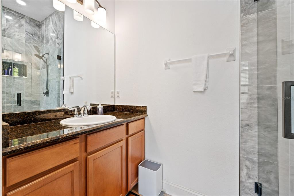 1819 Common Way Road, Unit 203 Orlando, FL 32814 - Photo 20 of 23 a bathroom with a granite countertop sink and a mirror
