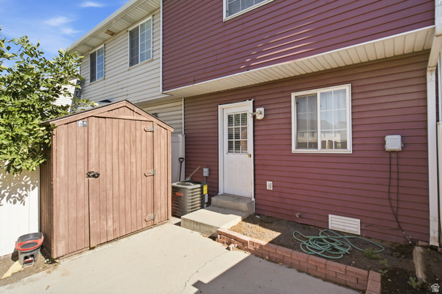 794 East 950 S Street Provo, UT 84606 - Photo 24 of 28 Private patio area featuring a storage shed, concrete pad, and brick-edged planting bed