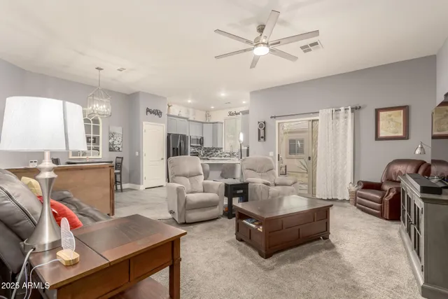 a living room with furniture kitchen view and a chandelier