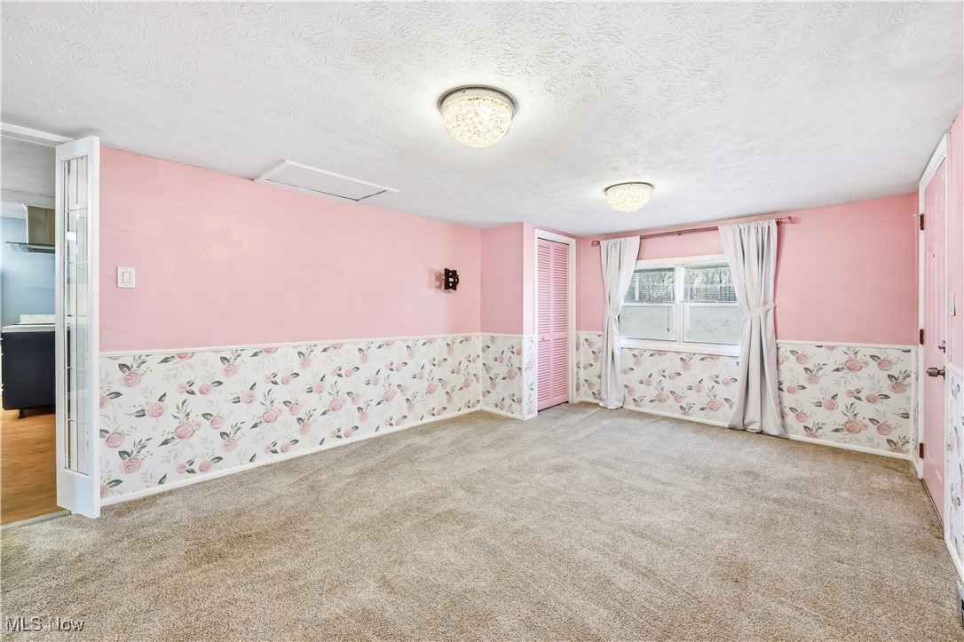 245 North Road Niles, OH 44446 - Photo 26 of 45 Empty room featuring a textured ceiling, a wainscoted wall, attic access, light carpet, and wallpapered walls