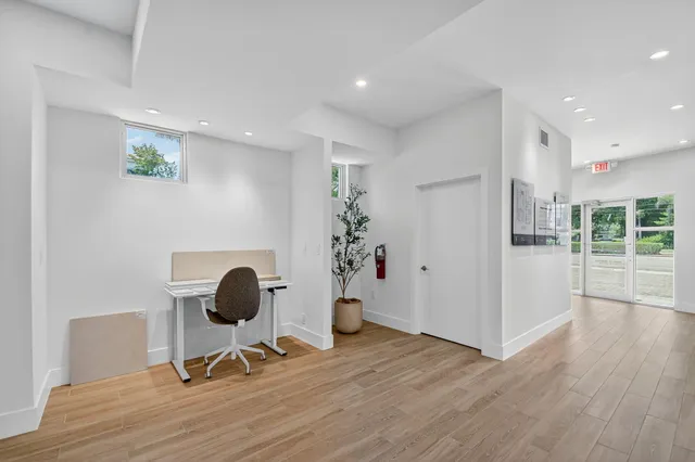 a view of a workspace with furniture and wooden floor