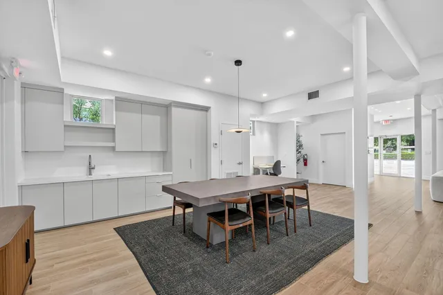 a dining hall with stainless steel appliances a table and chairs