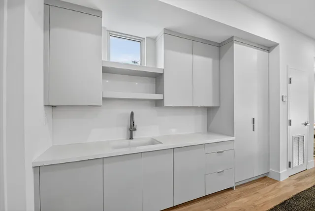 a kitchen with white cabinets and a sink